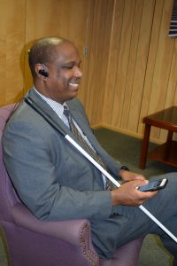 Blind person using iPhone with Bluetooth earpiece while using NFB-NEWSLINE app